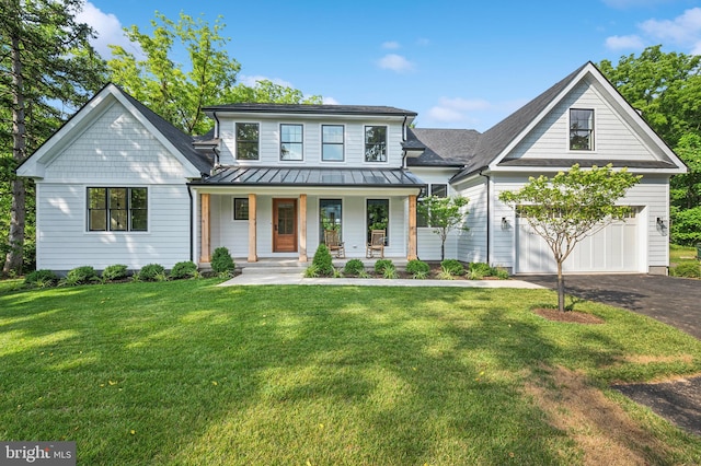 view of front of property featuring a front lawn, a porch, and a garage