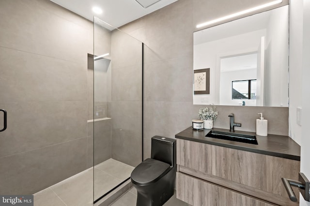 bathroom featuring tile patterned flooring, toilet, a tile shower, and vanity