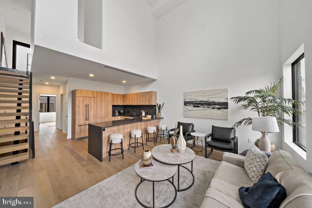 living room featuring a towering ceiling and light hardwood / wood-style floors