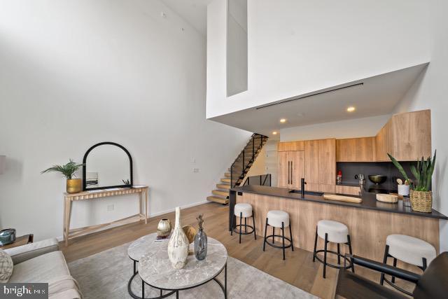 living room featuring a towering ceiling and light hardwood / wood-style flooring