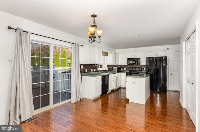 kitchen featuring decorative backsplash, a kitchen island, dark wood-type flooring, black appliances, and white cabinetry