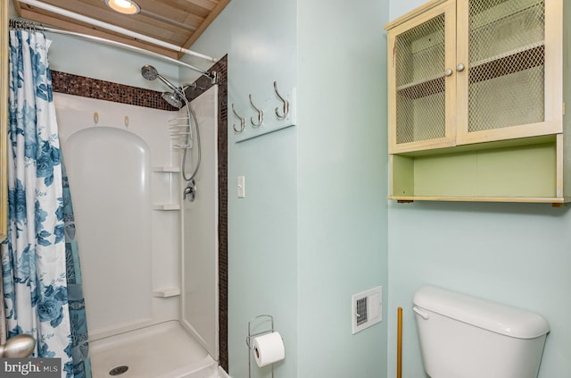 bathroom with toilet, curtained shower, and wood ceiling