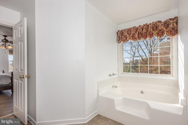 bathroom with a bathing tub, ceiling fan, and hardwood / wood-style floors