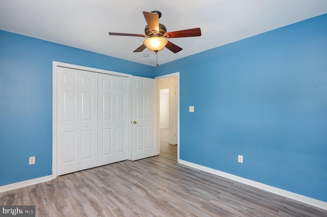 unfurnished bedroom with a closet, light hardwood / wood-style floors, and ceiling fan