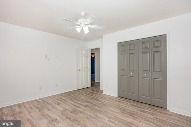 unfurnished bedroom with ceiling fan, light hardwood / wood-style floors, and a closet