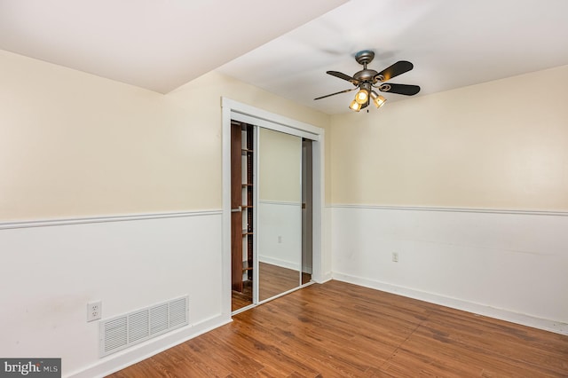 unfurnished bedroom with hardwood / wood-style floors, a closet, and ceiling fan