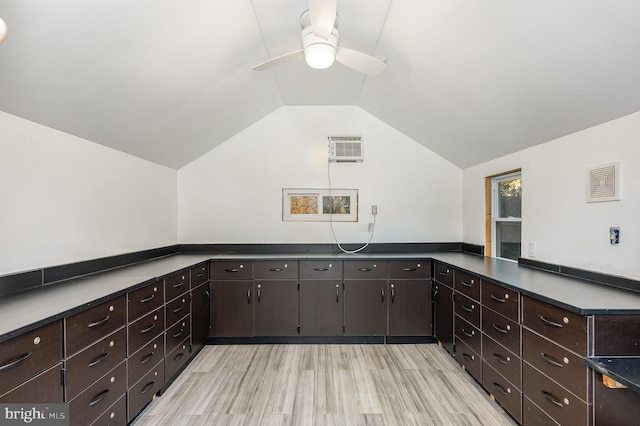 kitchen featuring lofted ceiling, dark brown cabinetry, kitchen peninsula, and light hardwood / wood-style flooring