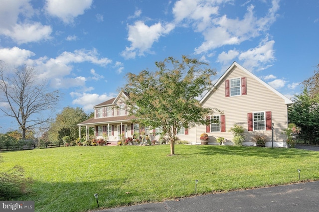 view of front of house with covered porch and a front lawn