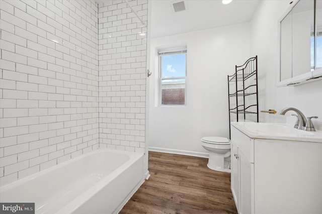 full bathroom featuring wood-type flooring, vanity, toilet, and tiled shower / bath combo