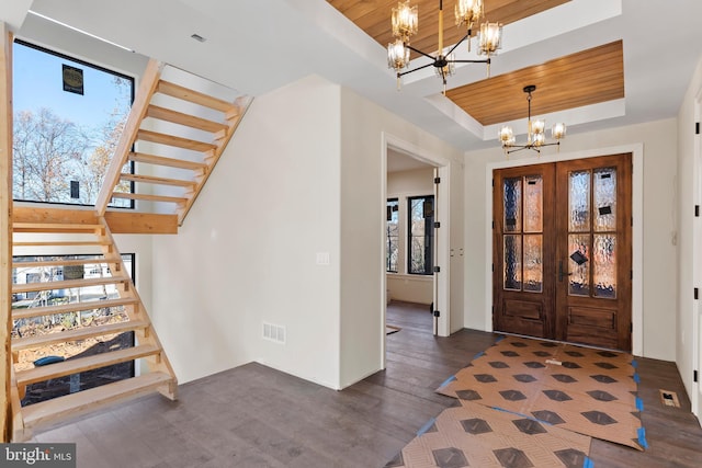 entryway featuring french doors, an inviting chandelier, dark hardwood / wood-style floors, a raised ceiling, and wooden ceiling