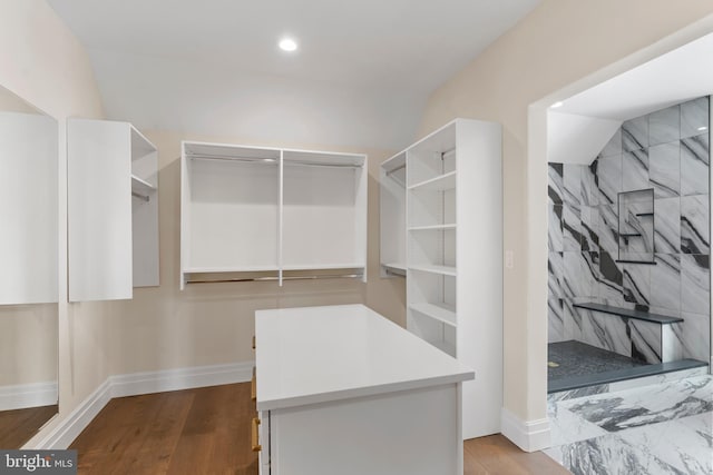 spacious closet with hardwood / wood-style flooring and lofted ceiling