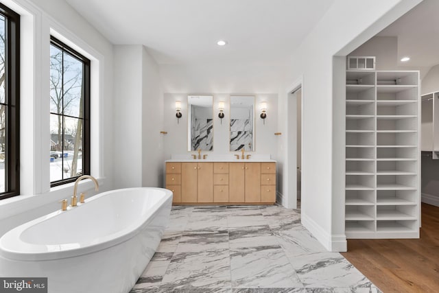 bathroom with built in shelves, a tub, and vanity