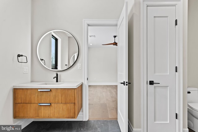 bathroom with toilet, ceiling fan, wood-type flooring, and vanity