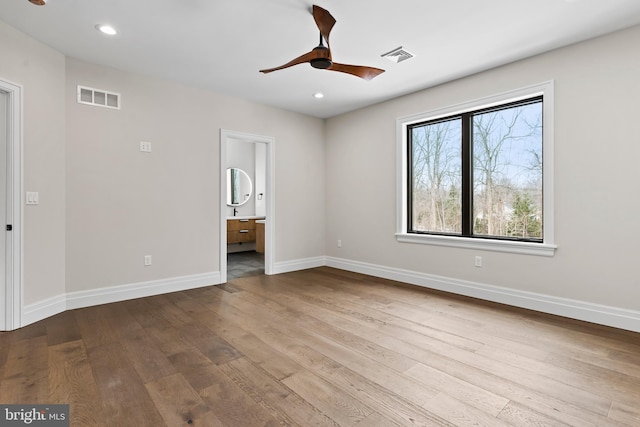 unfurnished bedroom with ensuite bathroom, ceiling fan, and light hardwood / wood-style flooring