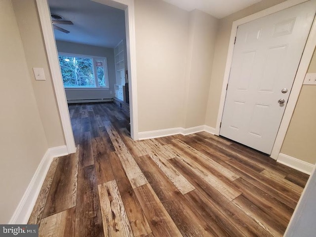 foyer entrance featuring baseboard heating, ceiling fan, and dark hardwood / wood-style flooring