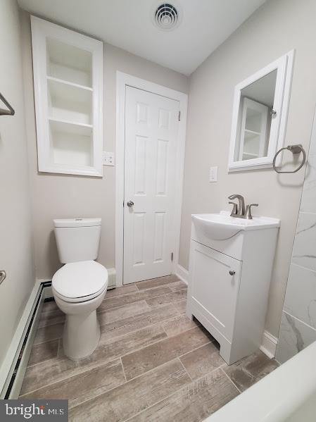 bathroom with vanity, a baseboard radiator, and toilet