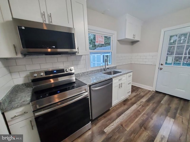 kitchen featuring light stone countertops, white cabinetry, sink, and appliances with stainless steel finishes