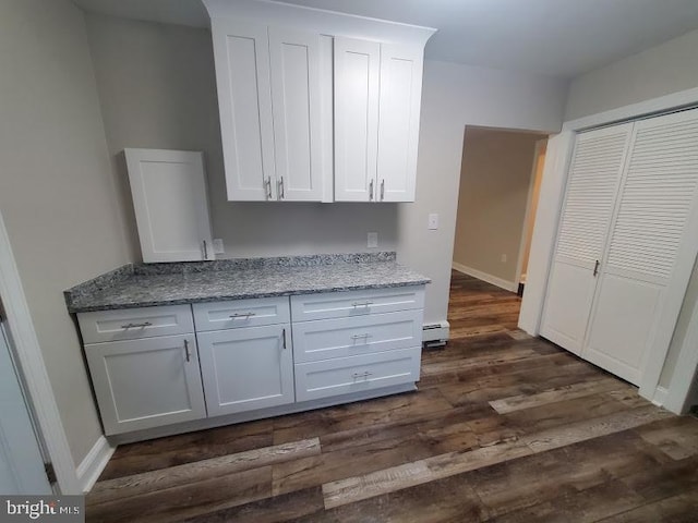 kitchen with dark hardwood / wood-style flooring, white cabinetry, light stone counters, and baseboard heating