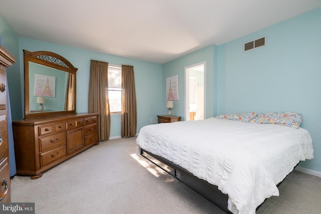 carpeted bedroom featuring ensuite bath