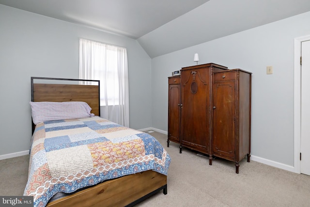 bedroom featuring vaulted ceiling and light carpet