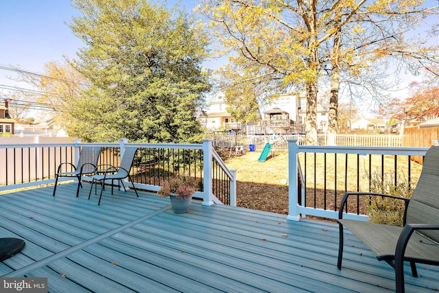 wooden terrace featuring a yard and a playground