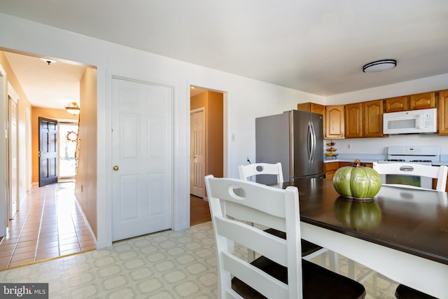 kitchen with light tile patterned floors and white appliances