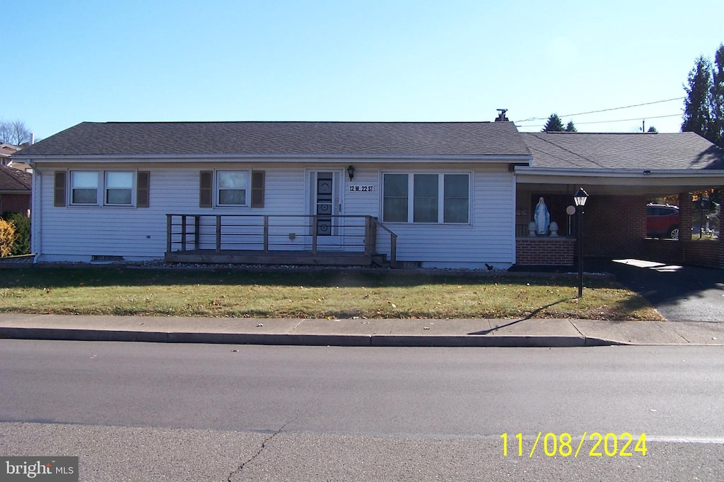 ranch-style house with a front lawn and a carport