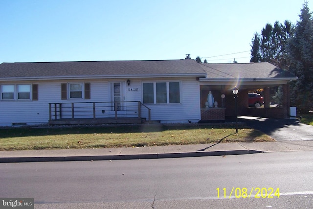 ranch-style home with a front lawn and a carport