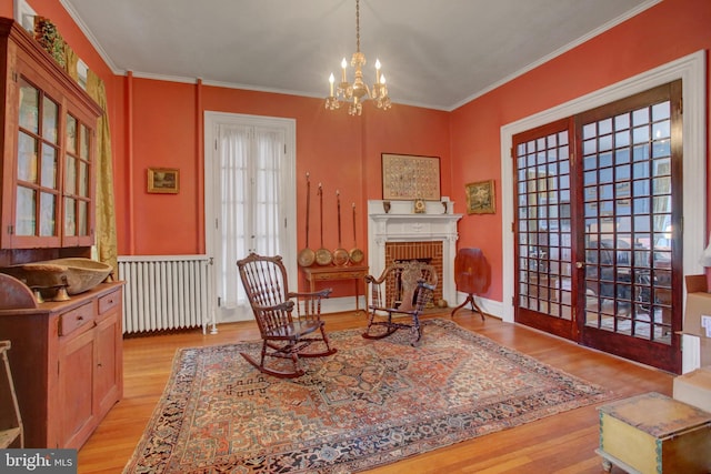 144 W Main St, Waynesboro, PA 17268 - sitting room featuring radiator heating unit, light wood-style floors, a chandelier, crown molding, and a fireplace