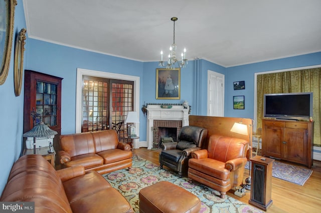 144 W Main St, Waynesboro, PA 17268 - living area with wood finished floors, a chandelier, a brick fireplace, and crown molding