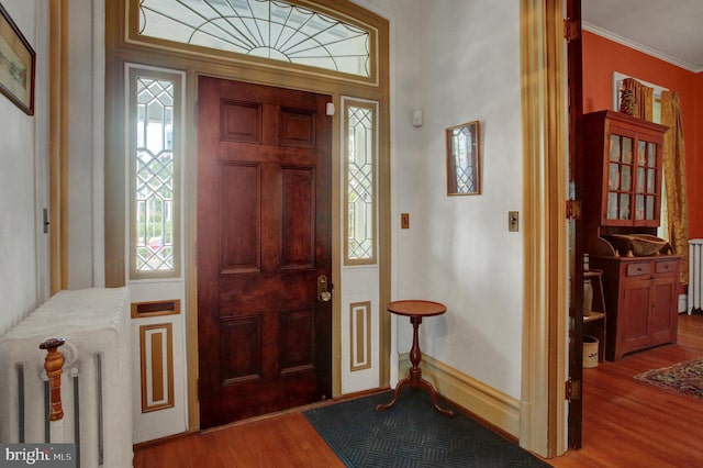 144 W Main St, Waynesboro, PA 17268 - foyer entrance with wood finished floors, radiator heating unit, ornamental molding, and baseboards
