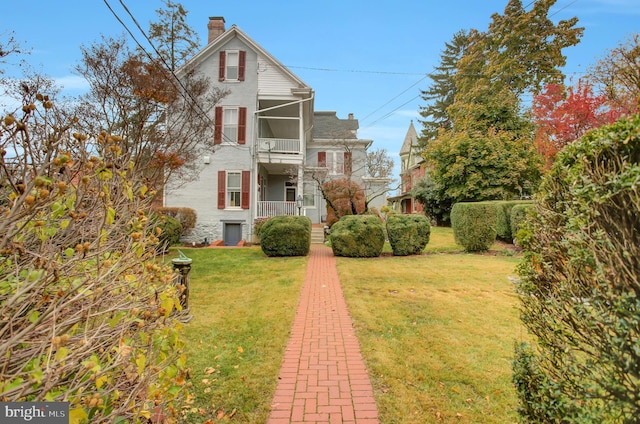 144 W Main St, Waynesboro, PA 17268 - view of front of house featuring a chimney, a balcony, and a front lawn