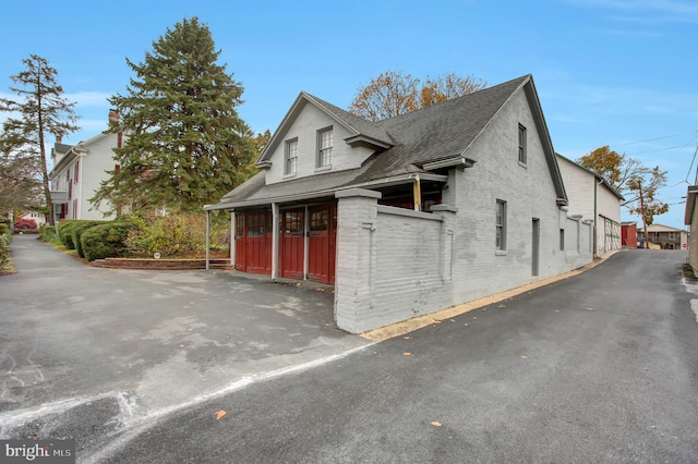 144 W Main St, Waynesboro, PA 17268 - view of side of property featuring a shingled roof and brick siding