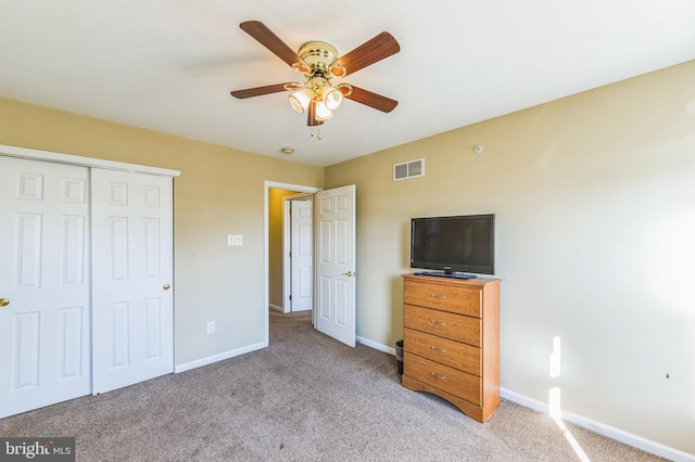 unfurnished bedroom with a closet, light colored carpet, and ceiling fan