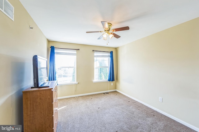 carpeted spare room featuring ceiling fan