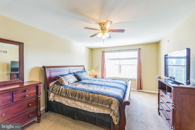 bedroom featuring multiple windows, ceiling fan, and light colored carpet