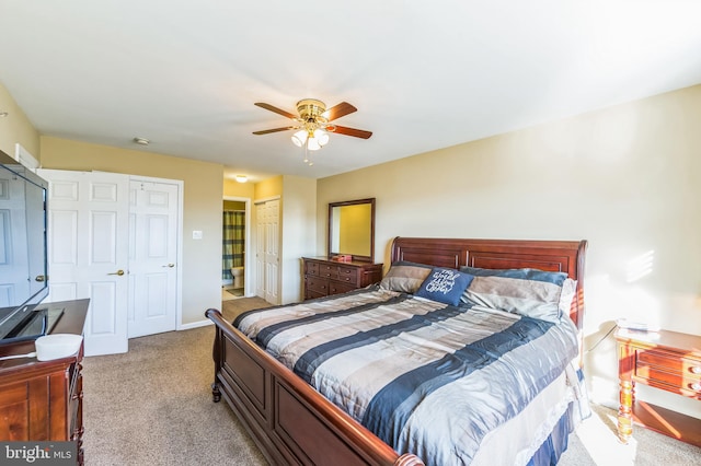 carpeted bedroom with two closets and ceiling fan