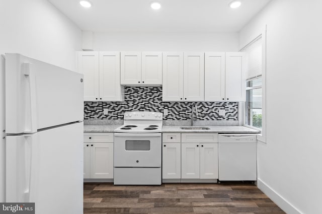 kitchen featuring sink, white appliances, dark hardwood / wood-style flooring, white cabinets, and decorative backsplash