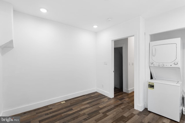 clothes washing area featuring dark wood-type flooring and stacked washer and dryer