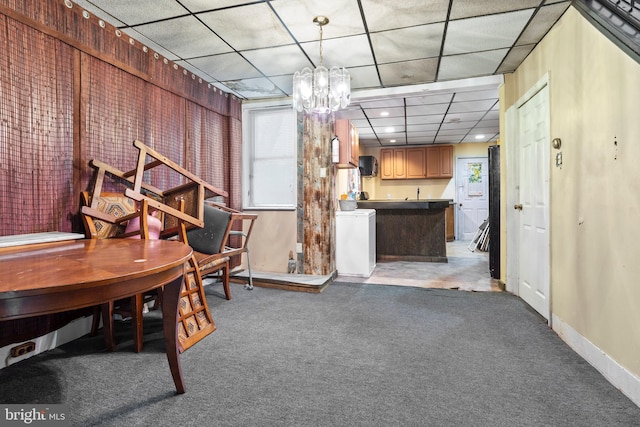 interior space with a paneled ceiling, washer / clothes dryer, and a chandelier