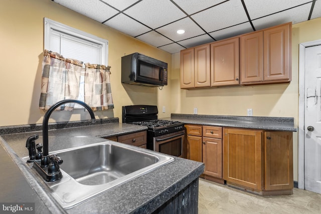 kitchen with a drop ceiling, black appliances, and sink