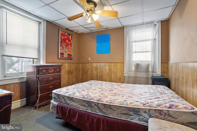 carpeted bedroom with a paneled ceiling, baseboard heating, and ceiling fan