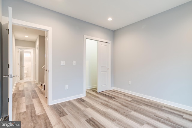 unfurnished bedroom featuring a closet and light hardwood / wood-style flooring