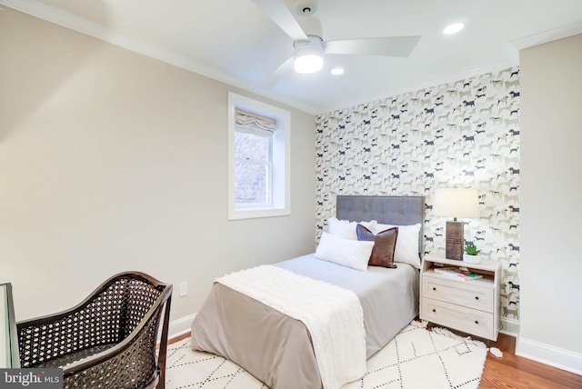 bedroom featuring light wood-type flooring, ceiling fan, and crown molding