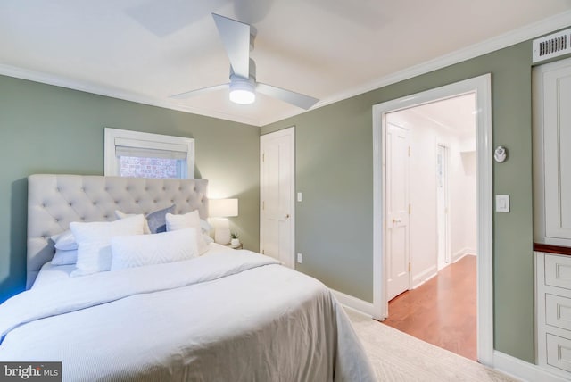 bedroom featuring light hardwood / wood-style floors, ceiling fan, and crown molding