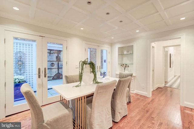 dining space featuring built in shelves, coffered ceiling, french doors, and light hardwood / wood-style floors