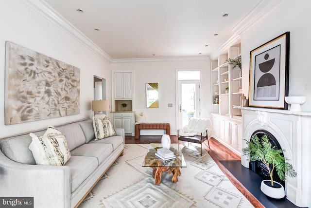 living room featuring light hardwood / wood-style floors, crown molding, and built in features