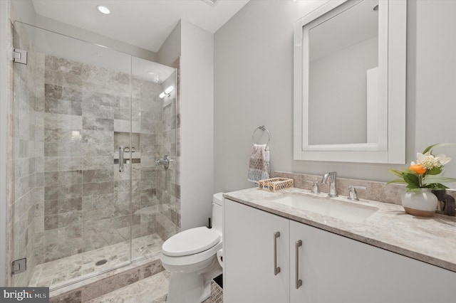 bathroom with walk in shower, vanity, and toilet