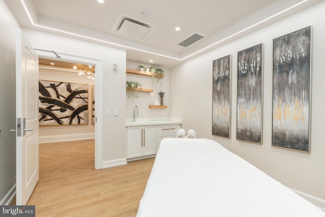 bedroom with sink and light hardwood / wood-style flooring