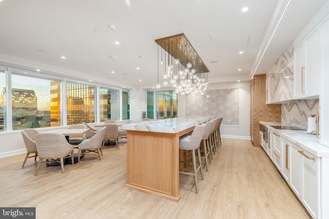 kitchen with light hardwood / wood-style flooring, white cabinetry, and plenty of natural light